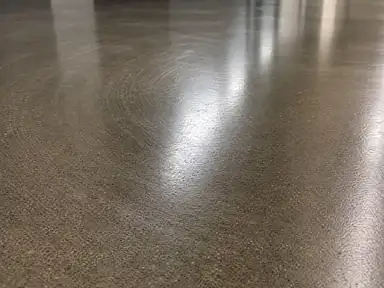 High-gloss burnished corridor floor showing the swirl pattern of a high-speed pass