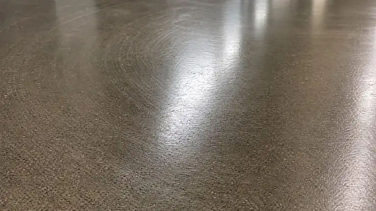 High-gloss burnished corridor floor showing the swirl pattern of a high-speed pass