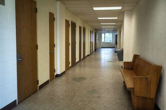 Public corridor in a county administrative building, terrazzo floor mopped and bench clear