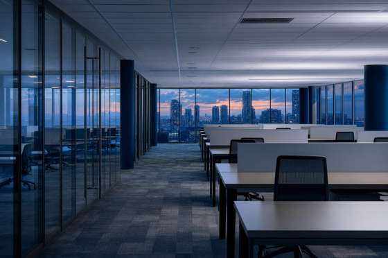 Open-plan office floor after hours, desks cleared and bins emptied ahead of the next day