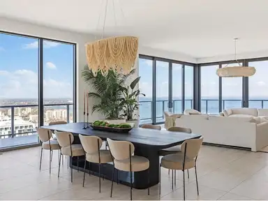 Penthouse living and dining room after a post-construction final clean, glazing clear to the bay