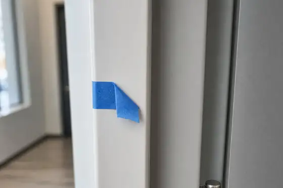 Punch-list tape flag marking an unfinished detail on a newly built commercial interior