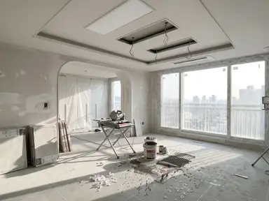Bare cement subfloor, tile saw and stacked tile boxes in an unfinished apartment interior before any cleaning