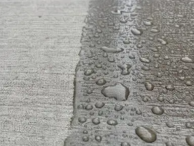 Water beading on a freshly sealed wet-look section of broom-finished concrete