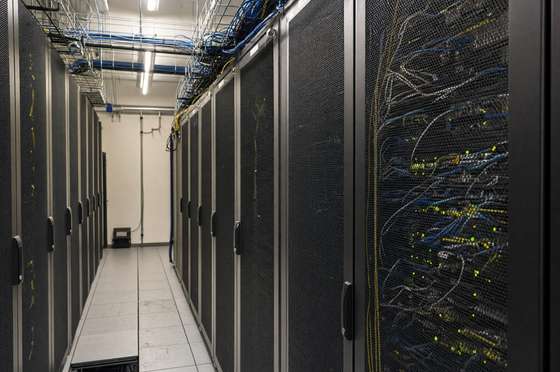 Cold aisle between server cabinets, raised access floor swept and cable trays clear of dust
